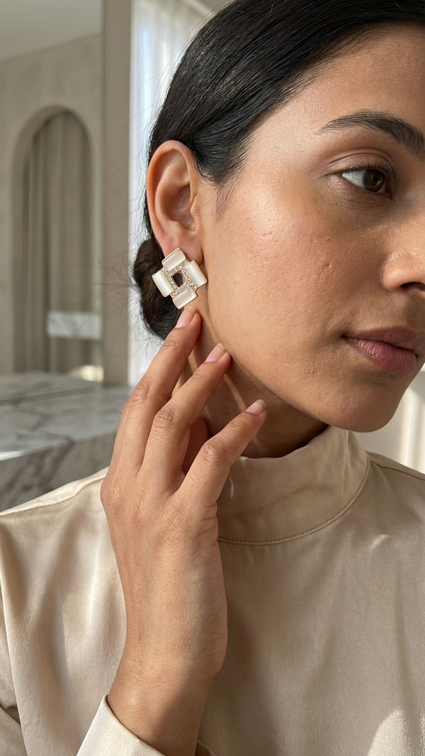 Woman wearing a pair of square earrings in an indoor setting