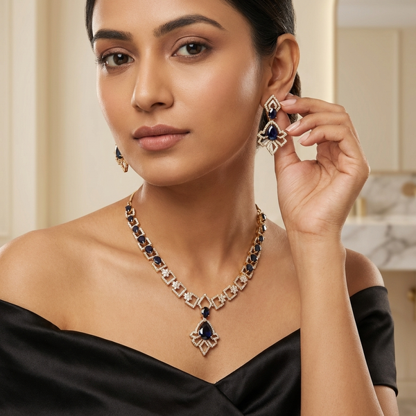 Woman wearing a necklace and earring set, holding up an earring to show detail.