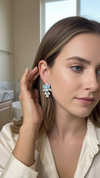 Woman wearing a floral earring in a bathroom setting